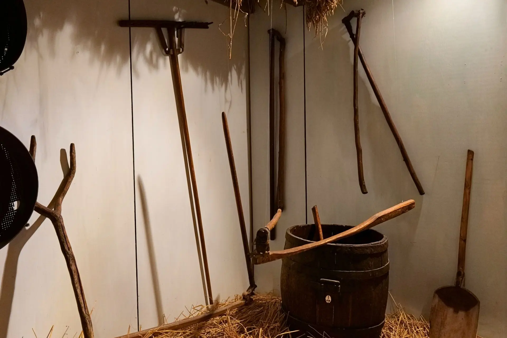 Care The picture shows a flail hanging in the air and two flails on the wall in the exhibition Farming Life at the Green Museum.