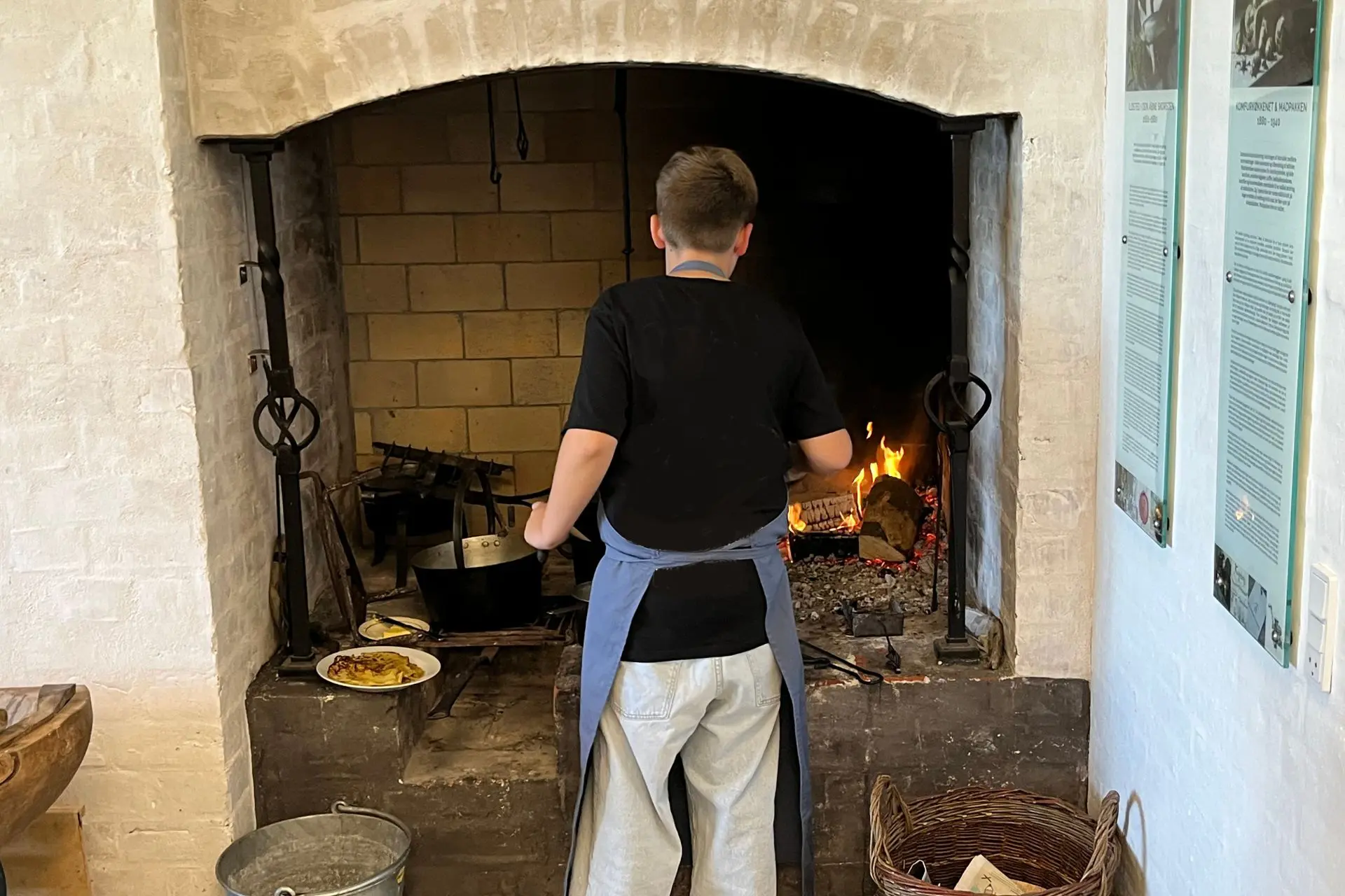 School student cooks food over a campfire for a teaching course about FOOD at the Green Museum