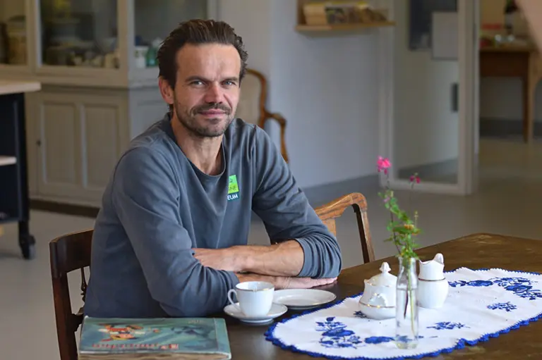 Do you remember Rasmus? Picture of museum educator with tea set and collection album from a Do you remember? visit to the Green Museum