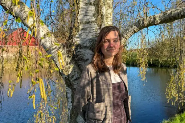 Thea Jul Nielsen steht neben ihrem Lieblingsbaum, der Hängebirke.