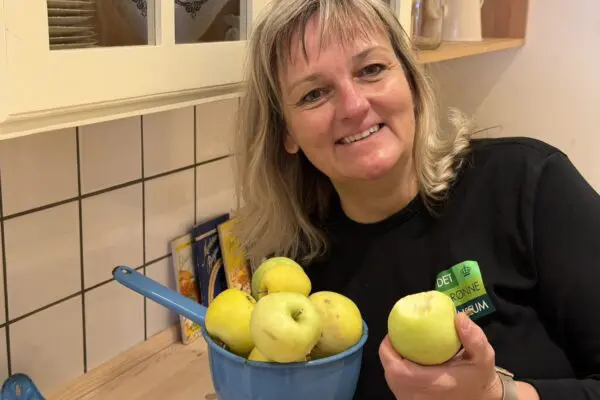 Bettina Buhl står med æbler i Madens Hus